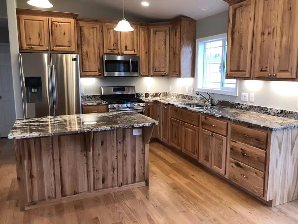 Custom kitchen with natural knotty wood cabinets, granite countertops, and stainless steel appliances